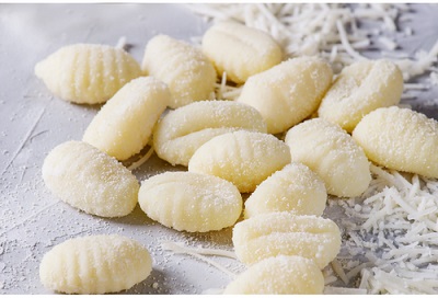 Gnocchi frais saupoudrés de parmesan pour la préparation des gnocchi à la courgette crémeuse et au jambon.